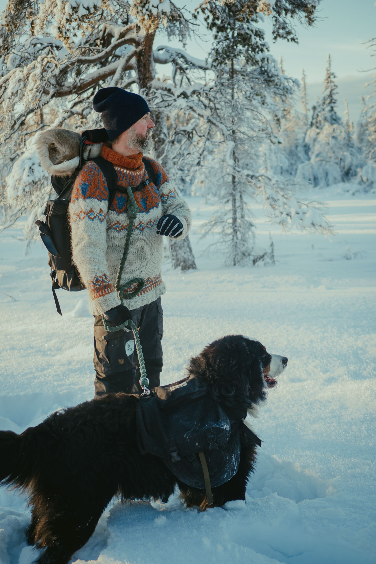 An outdoor guide and his dog in the snow