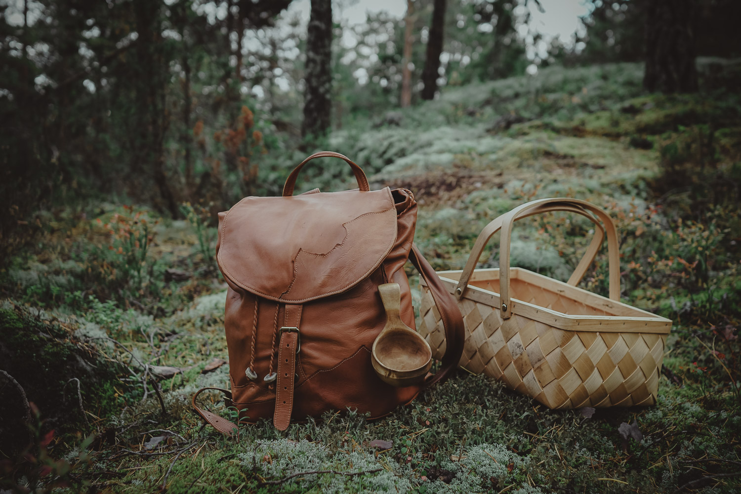 leather backpack and mushroom basket in a forest
