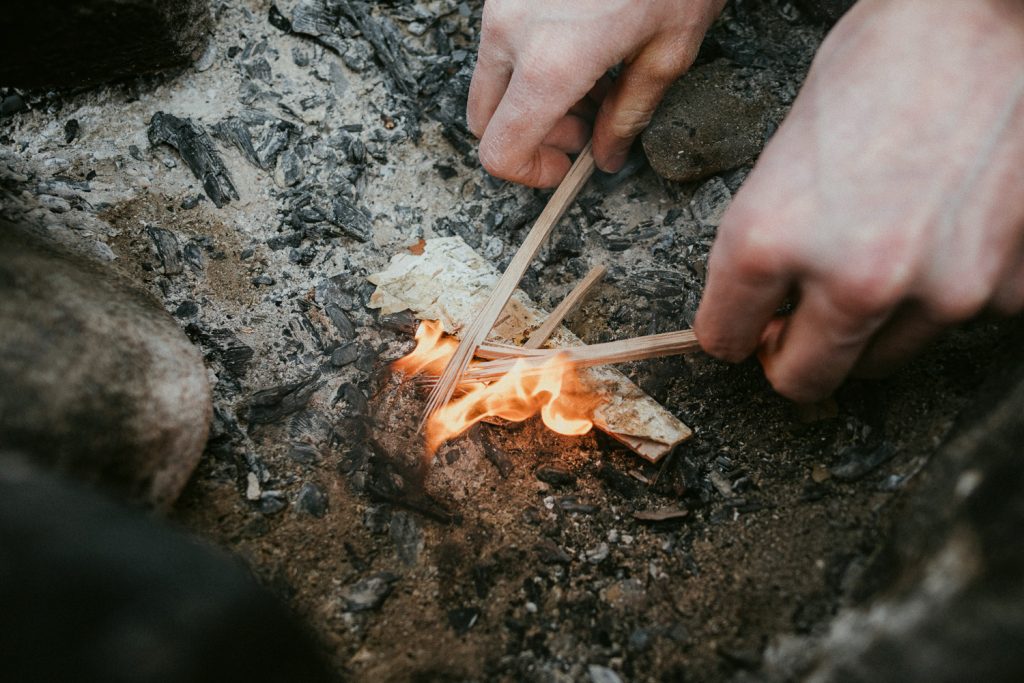hands feeding a fire